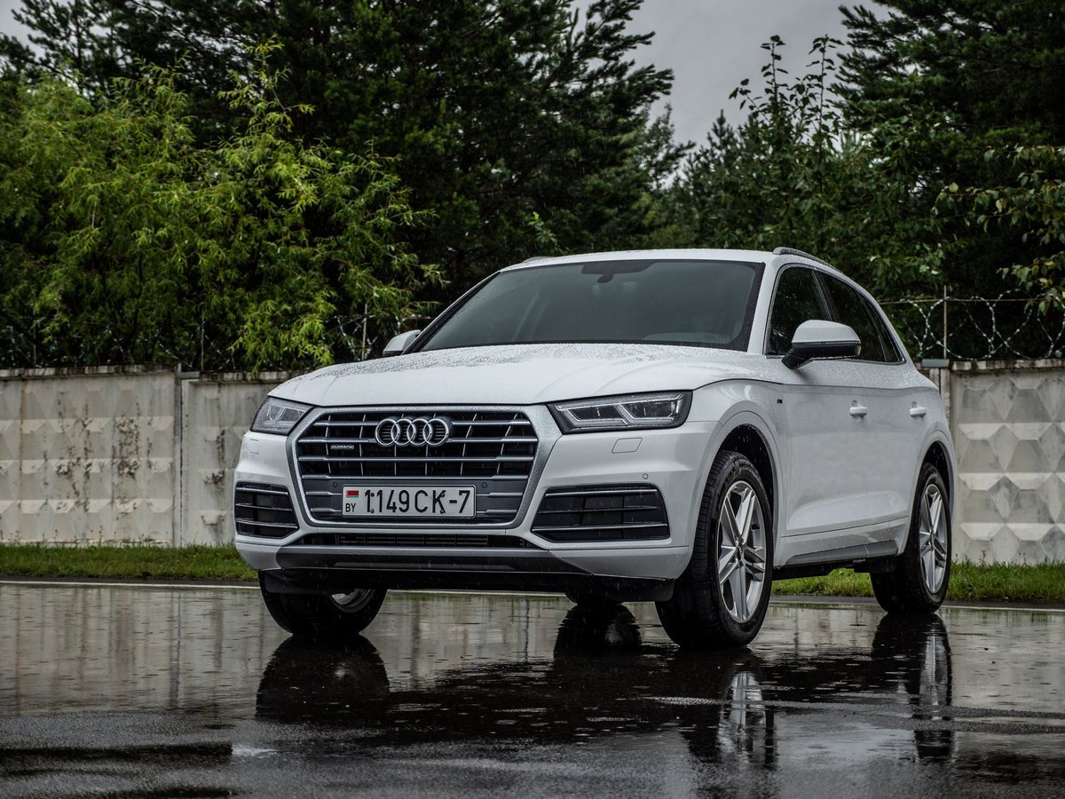 Minsk, Belarus - July 27, 2019: Audi Q5 2.0 TFSI Quattro 2019 model year drives on a wet asphalt road during test drive event.